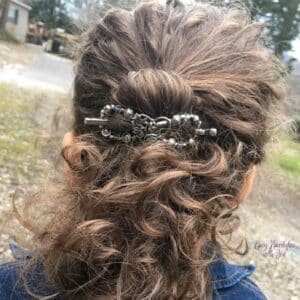 Back of Women's hair in a twist held with a Lilla Rose Flexi Clip.  She is enjoying the outdoors.  She is in the article Don't Let Environmental Factors Ruin Your Hair.